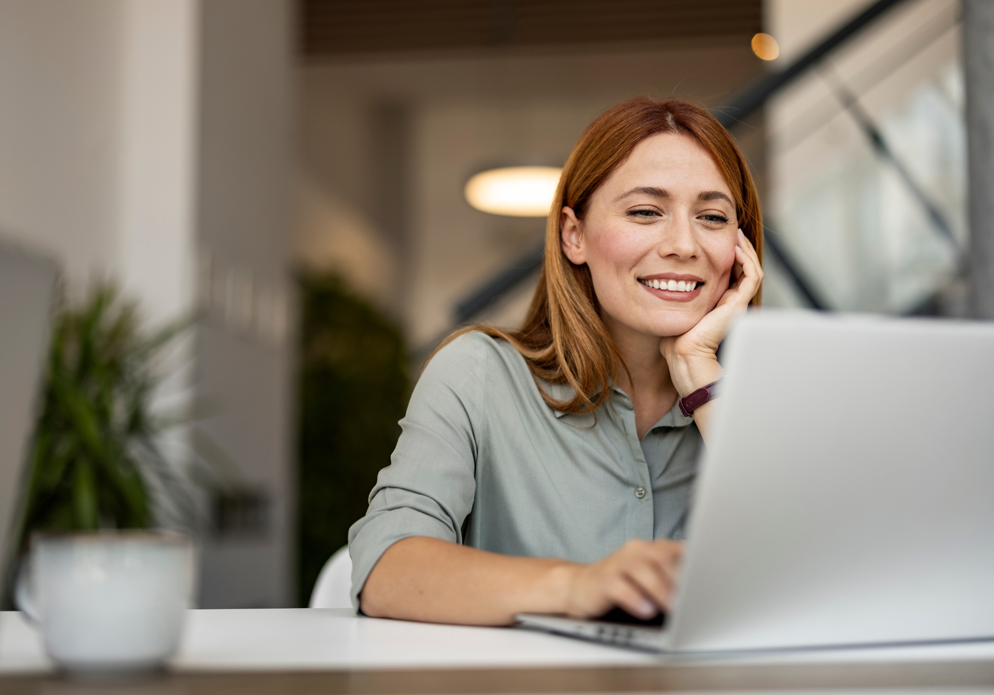 Woman using laptop and smiling. 